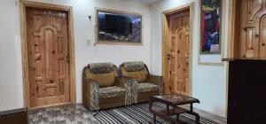 een woonkamer met twee stoelen en een tv bij Adventure Sarai Skardu in Skardu