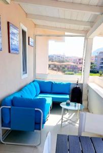 a living room with a blue couch and a table at Cottage DeLuxe in Golfo Aranci +35 photos