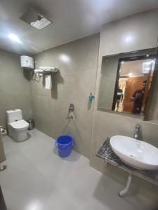 a bathroom with a sink and a toilet and a mirror at Hotel Maa Inn in New Delhi
