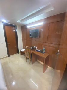 a hotel room with a desk and a television at Hotel Maa Inn in New Delhi