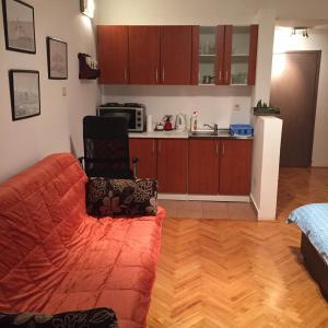 a living room with a couch and a kitchen at Apartment The Royal Pg in Podgorica