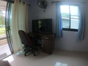 チャン島にあるGarden House Koh Changのデスク、椅子、テレビが備わる客室です。