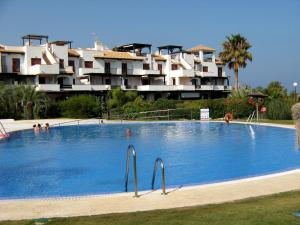 a large swimming pool in front of a building at Apartamento VenAVera Playa Jardines de Nuevo Vera L1-1D Primera Línea WIFI in Vera