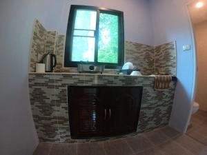 チャン島にあるGarden House Koh Changの窓付きの暖炉のあるキッチン