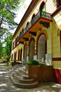 a building with stairs and a balcony on it at Garni Hotel Park in Palić