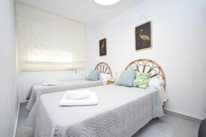 two beds in a room with white walls at Marina Baixa - FINCAS ARENA in Finestrat
