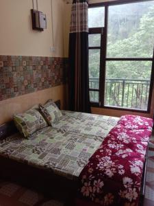DharampurにあるVaidik Thakur Home Stayの窓とベッドカバーが備わるドミトリールームのベッド1台分です。