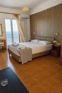 a bedroom with a large bed and a balcony at Beachfront Panorama Apartments in Kythira in Agia Pelagia Kythira +21 photos