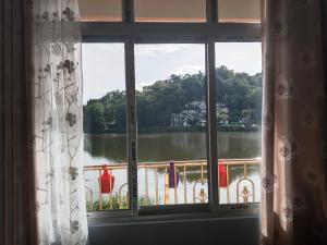 a window with a view of a body of water at Lake View Homestay in Mirik