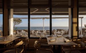 a restaurant with tables and chairs and a view of the ocean at Logis Hôtel Les Mouettes Restaurant ERIN - Larmor Plage, Proche de LORIENT in Larmor-Plage +19 photos