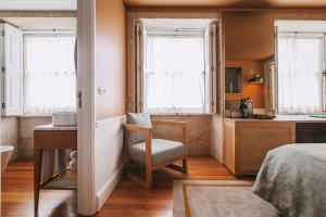a bedroom with a bed and a desk and windows at Gran Cruz House in Porto +62 photos