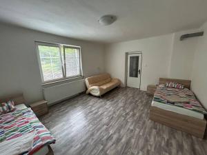 a room with two beds and a couch in it at Wooden Bridge Residence in Radošov