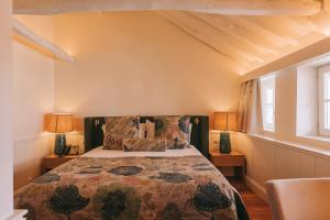 a bedroom with a bed and two windows at Gran Cruz House in Porto