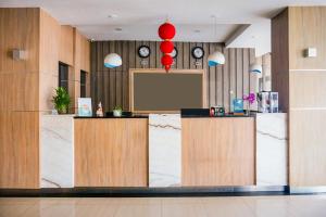 a lobby with two reception desks and a screen at Dancenter KR Hotel in Palembang