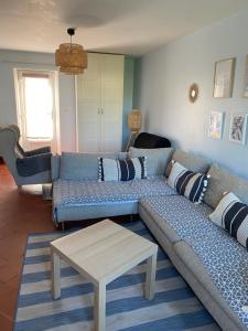 a living room with a couch and a table at Aux Petits Bonheurs in Grandcamp-Maisy