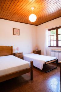 a bedroom with two beds and a wooden ceiling at Casa Montanha in Campo do Gerês