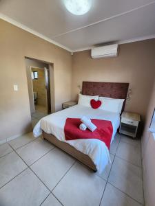 a bedroom with a large bed with a red blanket at VILLA HOLIDAYS - 14A Berea Road Margate in Margate