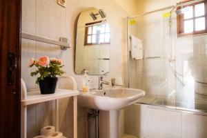 a bathroom with a sink and a shower and a mirror at Casa Montanha in Campo do Gerês +53 photos