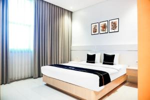 a bedroom with a large bed and a window at Dancenter KR Hotel in Palembang