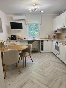 eine Küche mit Tisch und Stühlen und ein Esszimmer in der Unterkunft Apartament Victoria in Tîrnăveni + 14 Fotos