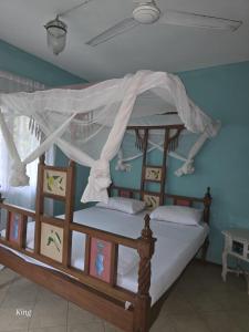 a bedroom with a wooden bunk bed with a canopy at Marially Luxury Bed and Breakfast in Malindi