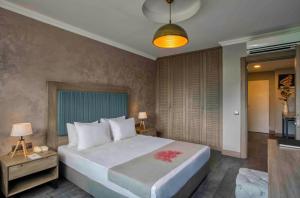 a bedroom with a large white bed with a red flower on it at Labranda TMT Bodrum in Bodrum City