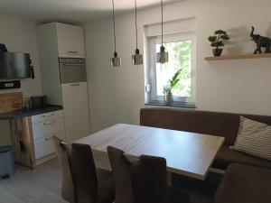 a kitchen with a wooden table and chairs in a room at Haus am Wald in Weida