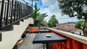 a balcony with a table and benches on it at Tuwin Guest House Syariah in Yogyakarta