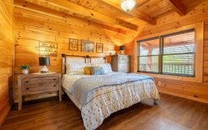 a bedroom with a bed in a wooden cabin at Wanderlust in Sevierville +21 photos