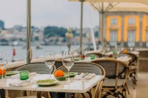 a table with wine glasses and plates of food on it at Gran Cruz House in Porto