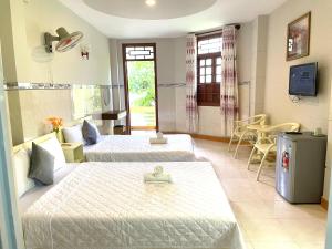 a hotel room with two beds and a television at Khách sạn THIÊN lý in Liên Trì (4)