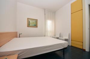 a bedroom with a large white bed and a chair at Residence Garuda in Cavallino-Treporti +57 photos