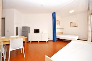 a room with a table and a bed and a desk at Residence Garuda in Cavallino-Treporti