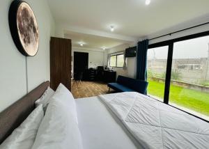 Un dormitorio con una cama y una ventana grande. en Urban Ground Suite, en Baños
