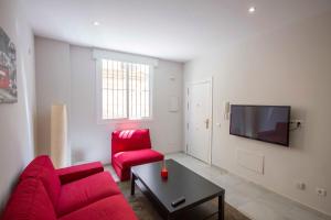 マラガにあるLivemalaga Merced Apartamentoのリビングルーム(赤いソファ、赤い椅子付)