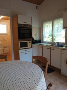 a kitchen with a table and a microwave at Gîte 2 personnes, proche mer in Challans +11 photos