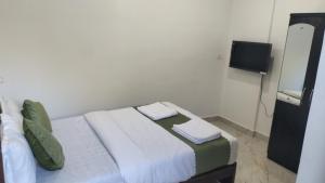 a bedroom with a bed with two towels on it at cbc joy resort in Calangute