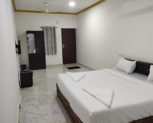 a bedroom with a large white bed in a room at cbc joy resort in Calangute