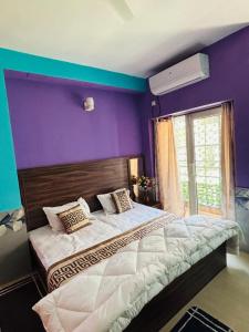 a bedroom with purple walls and a large bed at Luxury & Peaceful stay in Omaxe in Vrindāvan