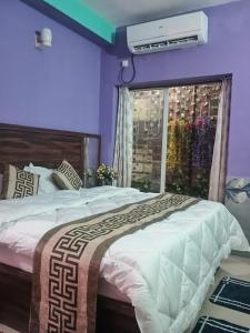 a bedroom with a large bed and a window at Luxury & Peaceful stay in Omaxe in Vrindāvan