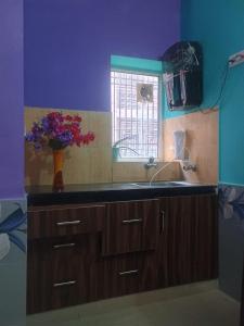 a kitchen with a sink and a vase of flowers at Luxury & Peaceful stay in Omaxe in Vrindāvan