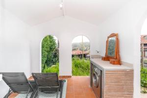 a room with chairs and a mirror and a washing machine at Maravillosa casa con jardín cerca de playa en centro de Asturias in Llodares
