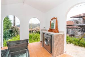 a washing machine in a room with a mirror at Maravillosa casa con jardín cerca de playa en centro de Asturias in Llodares