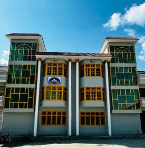 een gebouw met gele ramen en een blauwe lucht bij Adventure Sarai Skardu in Skardu