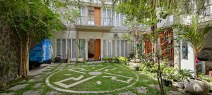 a garden in front of a house with a labyrinth in the grass at RADJIMIN Guesthouse in Adi Sutjipto