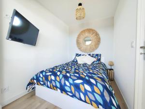 a bedroom with a bed and a flat screen tv at Le Cosy Les Pieds Dans L'eau in Le Grau-du-Roi