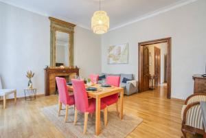 une salle à manger avec une table et des chaises roses dans l'établissement Superbe appartement 95m2 proche Arènes- parking offert, à Nîmes