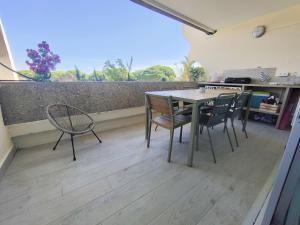 a patio with a table and chairs on a balcony at Le Cosy Les Pieds Dans L'eau in Le Grau-du-Roi