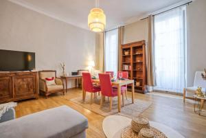 un salon avec une table et des chaises rouges dans l'établissement Superbe appartement 95m2 proche Arènes- parking offert, à Nîmes