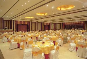 a large banquet hall with yellow tables and chairs at NIRVANA Luxury Hotel l Ludhiana in Ludhiana +69 photos